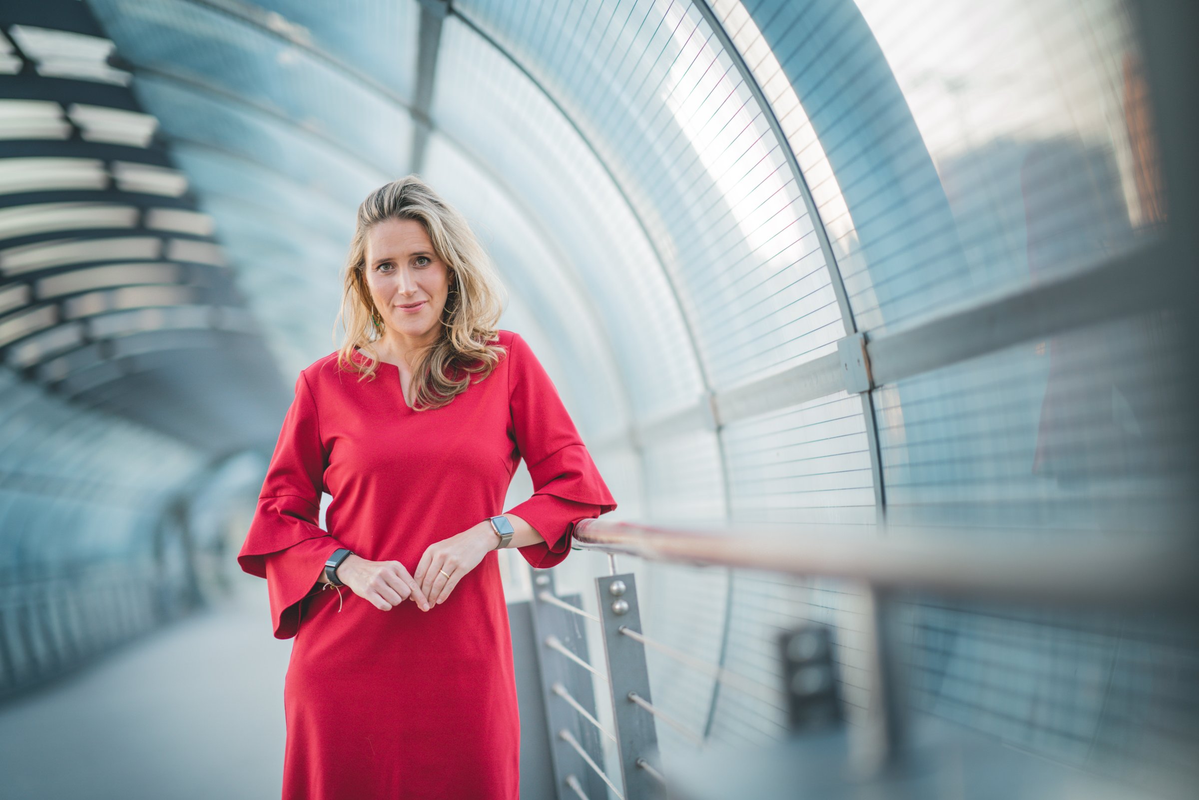 Svea Eckert im roten Kleid in einem Glasgang