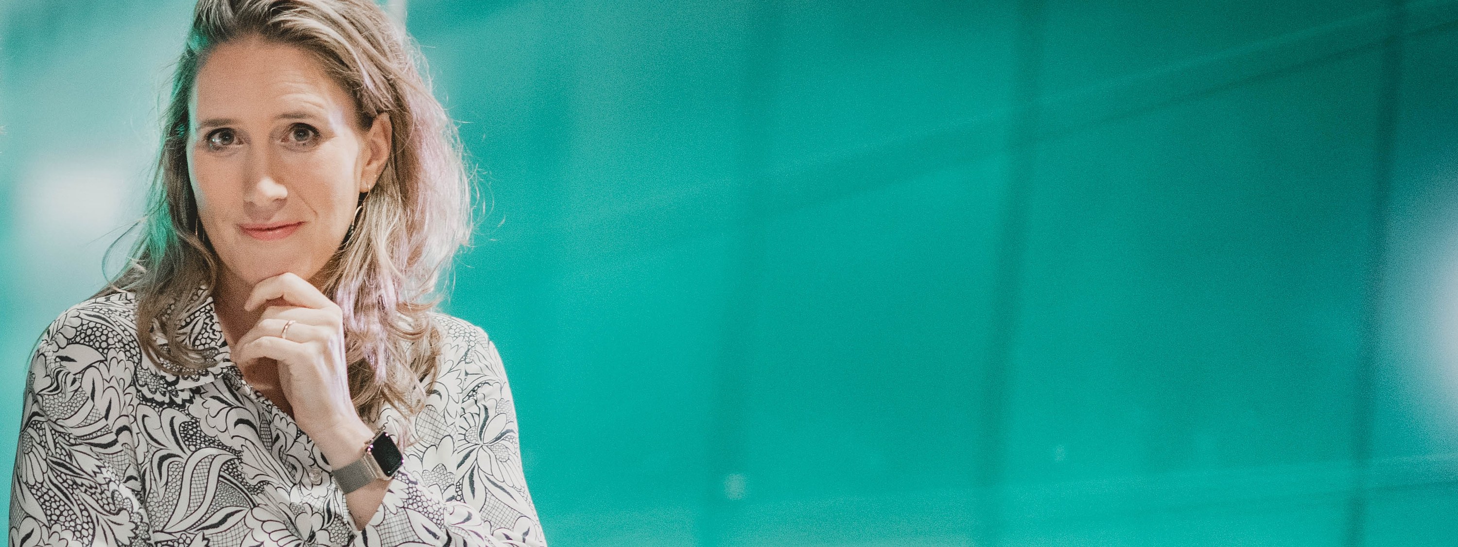 Svea Eckert vor einer türkis leuchtenden Glaswand