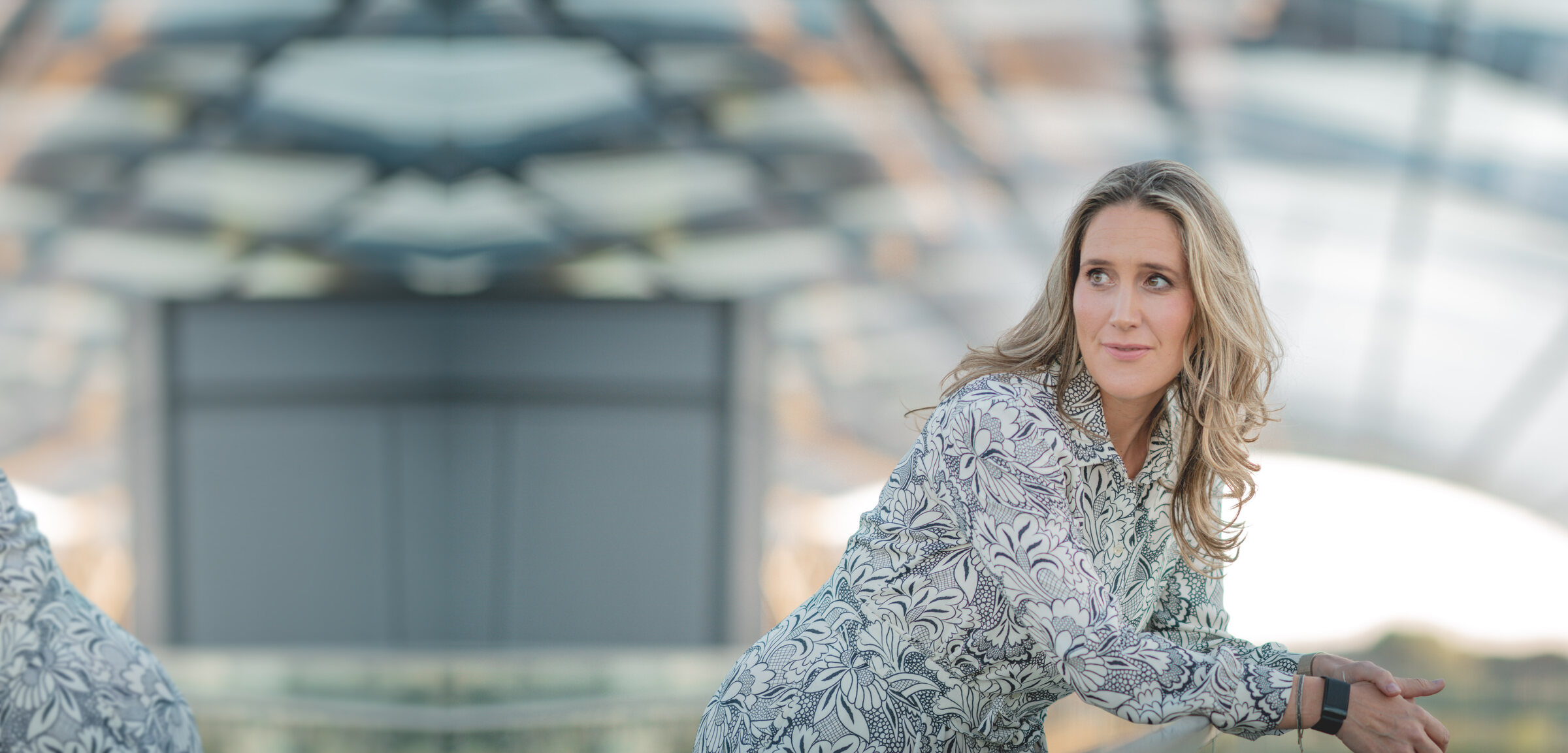 Svea Eckert unter einem Glasdach, den Blick zur Seite gerichtet