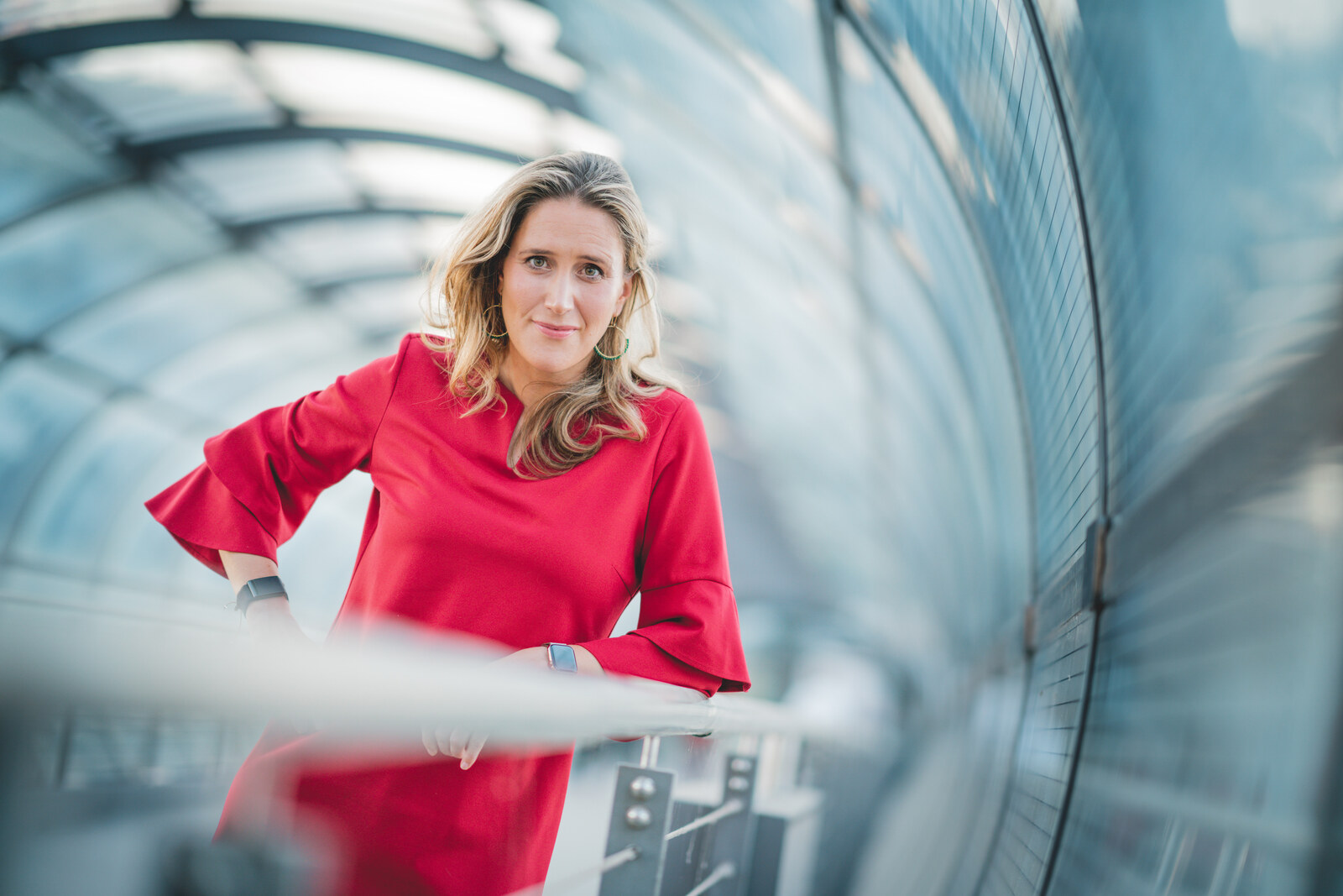 Svea Eckert im roten Kleid in einem Glasgang